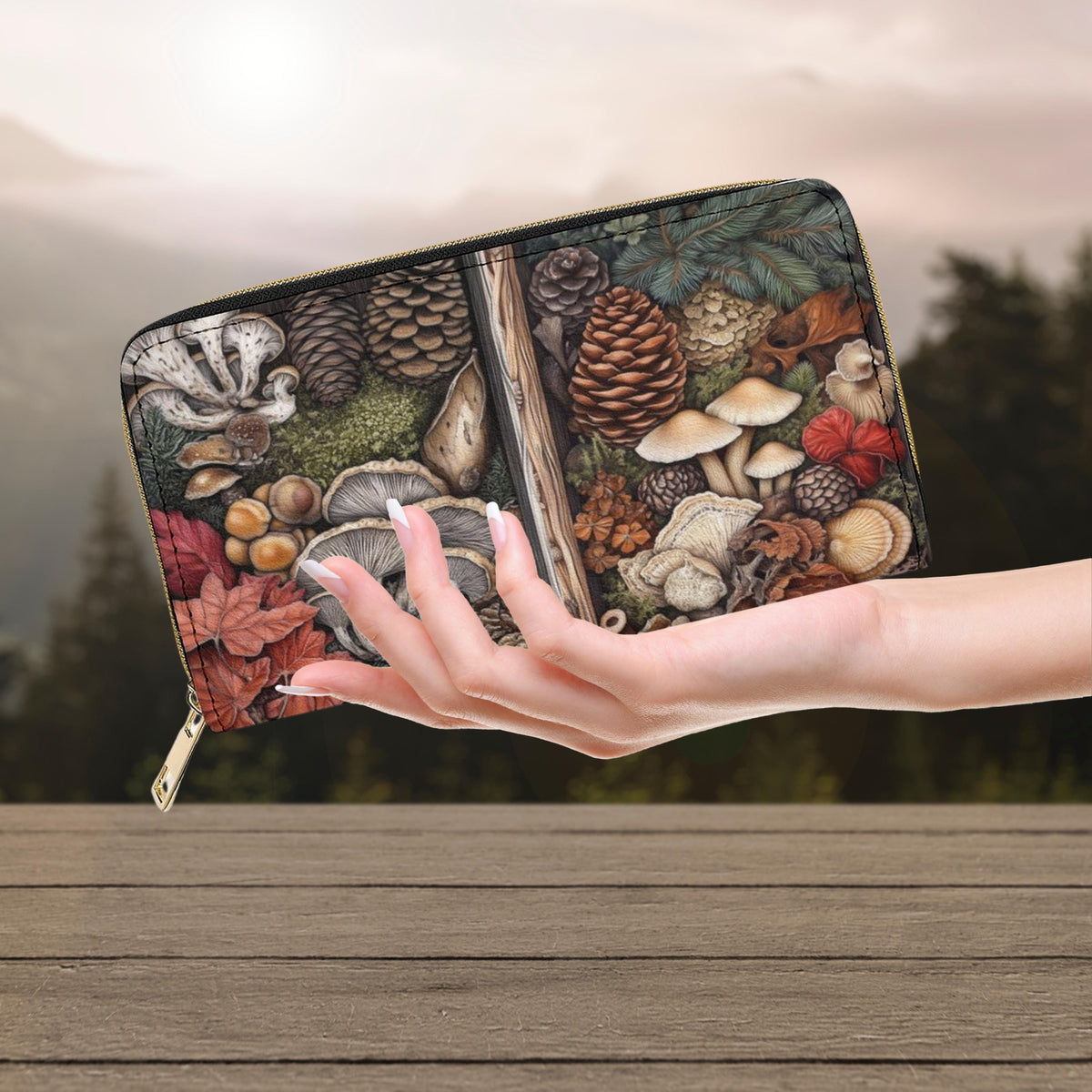 Hand holding a wallet with nature-themed design on a wooden surface