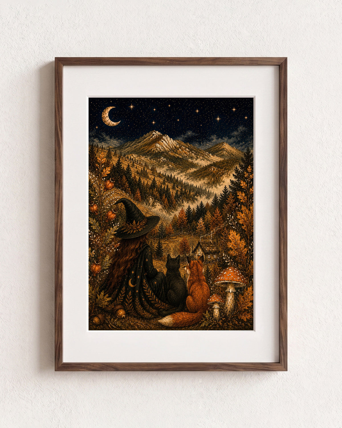 A framed art print featuring a whimsical autumn night scene with a witch, cat, fox, mountains, and a crescent moon, displayed on a textured white wall.