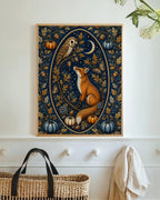 A framed vertical art print featuring a fox, owl, moon, and pumpkins in an ornate navy and gold pattern, displayed on a white wall above a woven basket.
