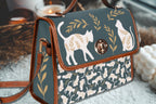 White cats satchel handbag by Fae & Magpie, featuring a charming white cat design, leather strap, and structured shape.