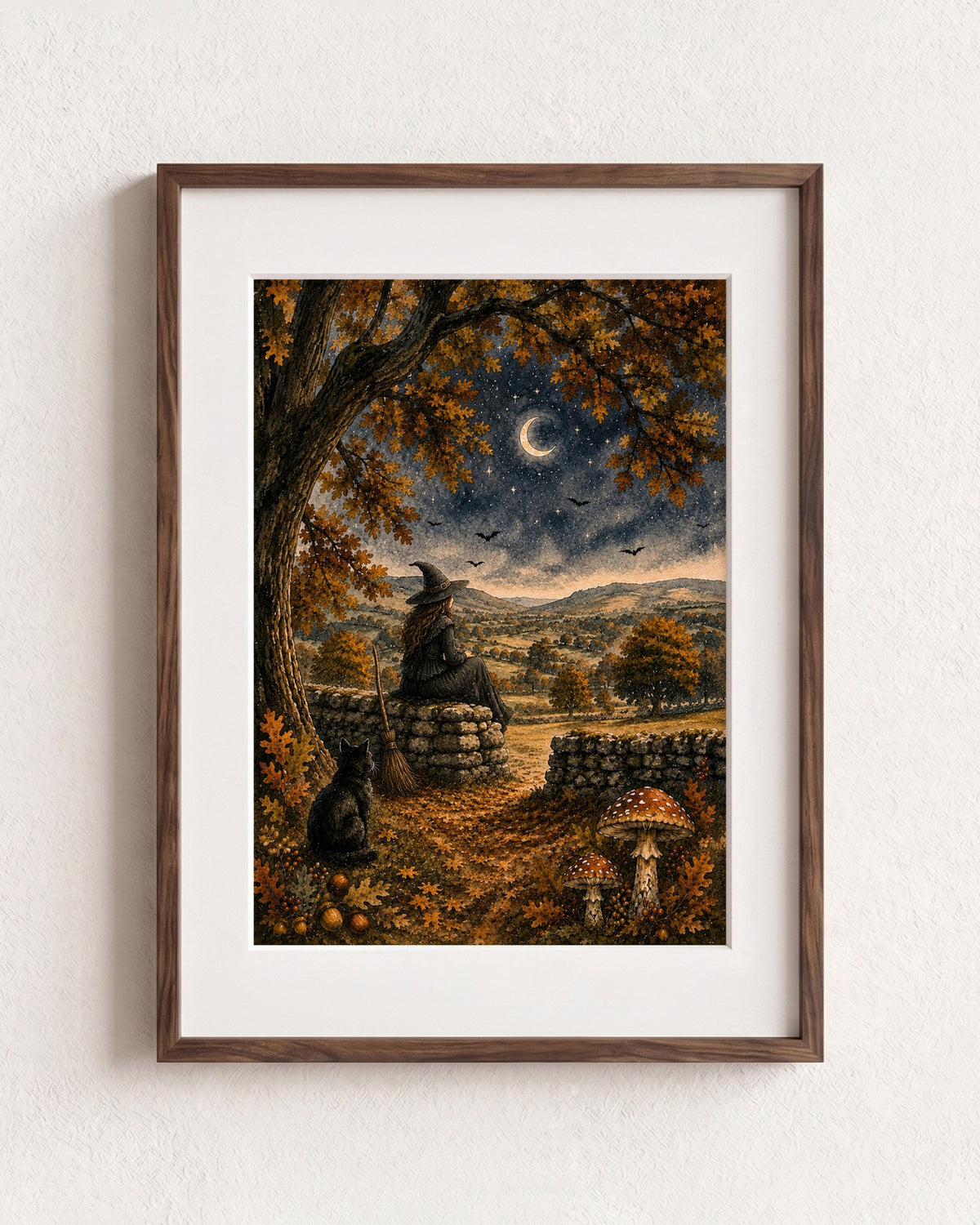 A framed art print featuring a witch sitting on a stone wall under a crescent moon, surrounded by autumn trees, a stone path, and mushrooms, displayed on a textured white wall.