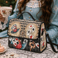 Handbag with playing card design on a table with tea and pastries