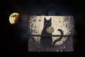 Black cat-shaped satchel bag by Fae & Magpie featuring a sleek black leather design and a top handle.