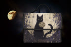Black cat-shaped satchel bag by Fae & Magpie featuring a sleek black leather design and a top handle.