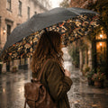 Person holding a floral umbrella walking down a rain-soaked street