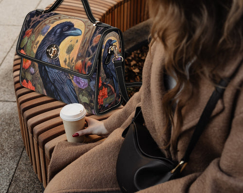 Fae & Magpie black leather satchel handbag with top handle and adjustable shoulder strap, featuring a classic silhouette and minimal design.