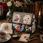 Handbag with playing card design on a table with tea, cards, and books