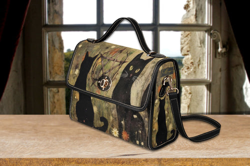 Black Cats Satchel Bag by Fae & Magpie featuring a sleek black leather design with a cat motif and sturdy handle.