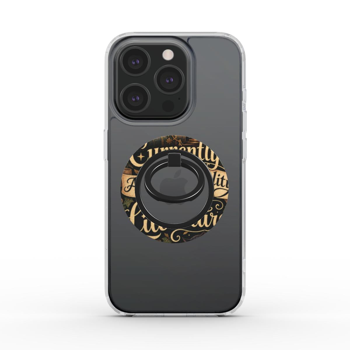 A dark gray phone case with a clear bumper edge, featuring a circular gold and black decorative graphic with gothic lettering and a black ring stand in the center.