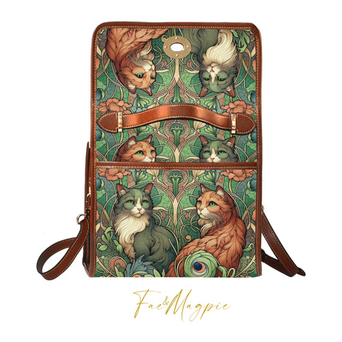 Fae & Magpie cats green satchel handbag with top handle and adjustable strap, featuring a stylish, structured design.