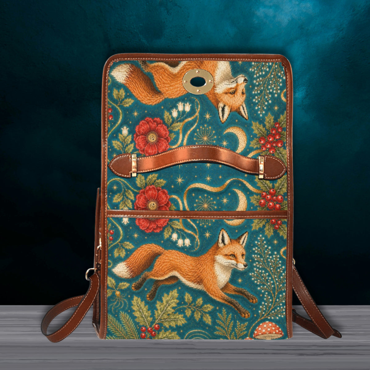 A rectangular backpack with a teal and brown leather frame, decorated with an intricate print of foxes, red flowers, and foliage on a dark teal textured background.