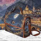 Handbag with artistic design of mountains and cityscape, placed on a textured surface.