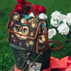 Handbag with a cat design on a decorative stand with flowers in the background