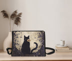 Black cat-shaped satchel bag from Fae & Magpie with adjustable strap and detailed feline design.