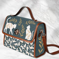 White Fae & Magpie cats satchel handbag with structured design and top handle, featuring a charming feline motif.