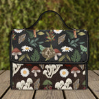 Handbag with nature-themed design featuring mushrooms and flowers on a wooden surface.