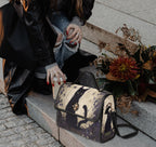 Black cat satchel bag by Fae & Magpie, featuring a sleek dark design with a sturdy handle and silver hardware.