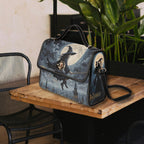 Handbag with a witch and dog design on a wooden table